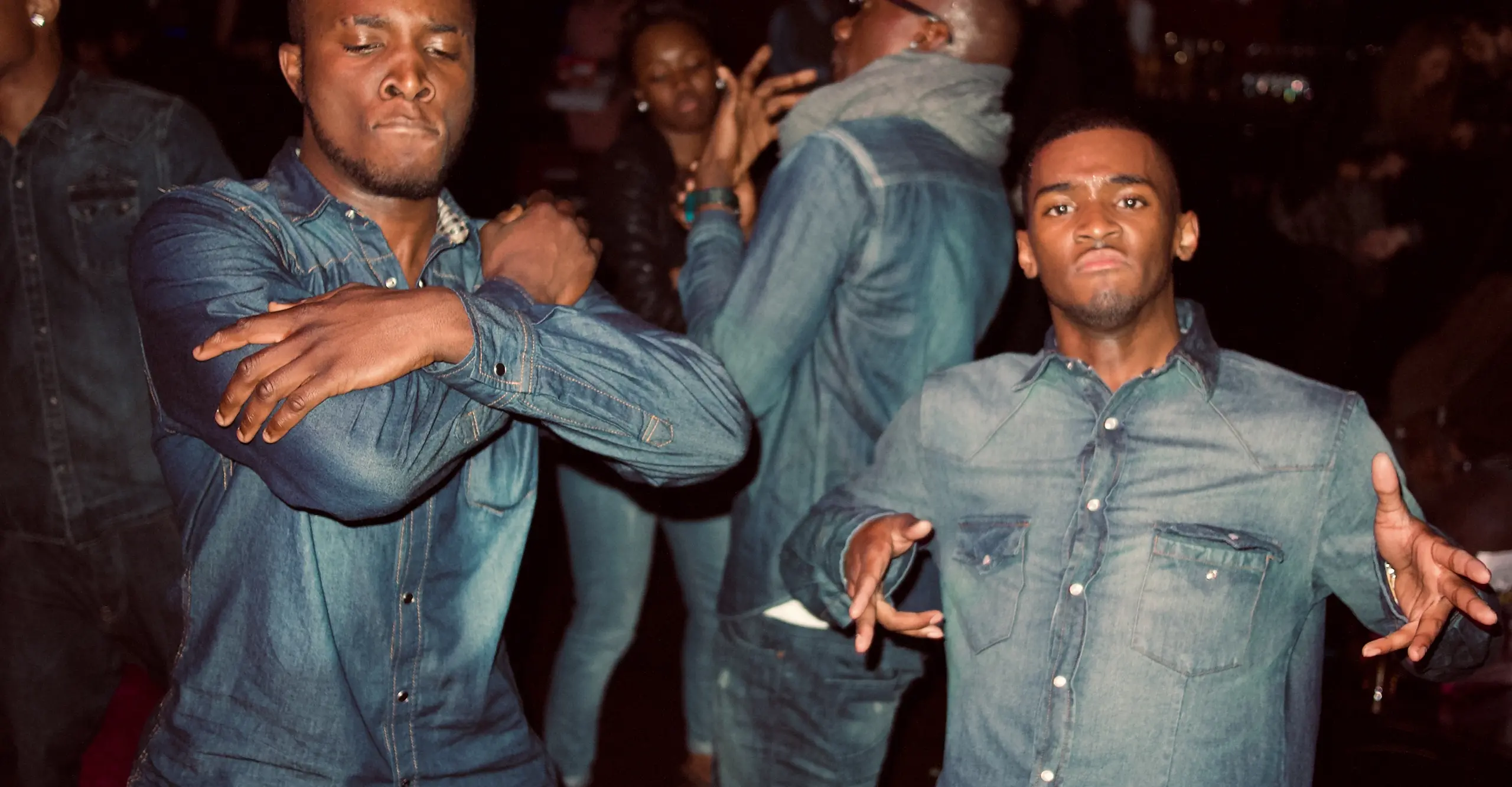 Three Black male presenting figures in head to toe denim dancing 