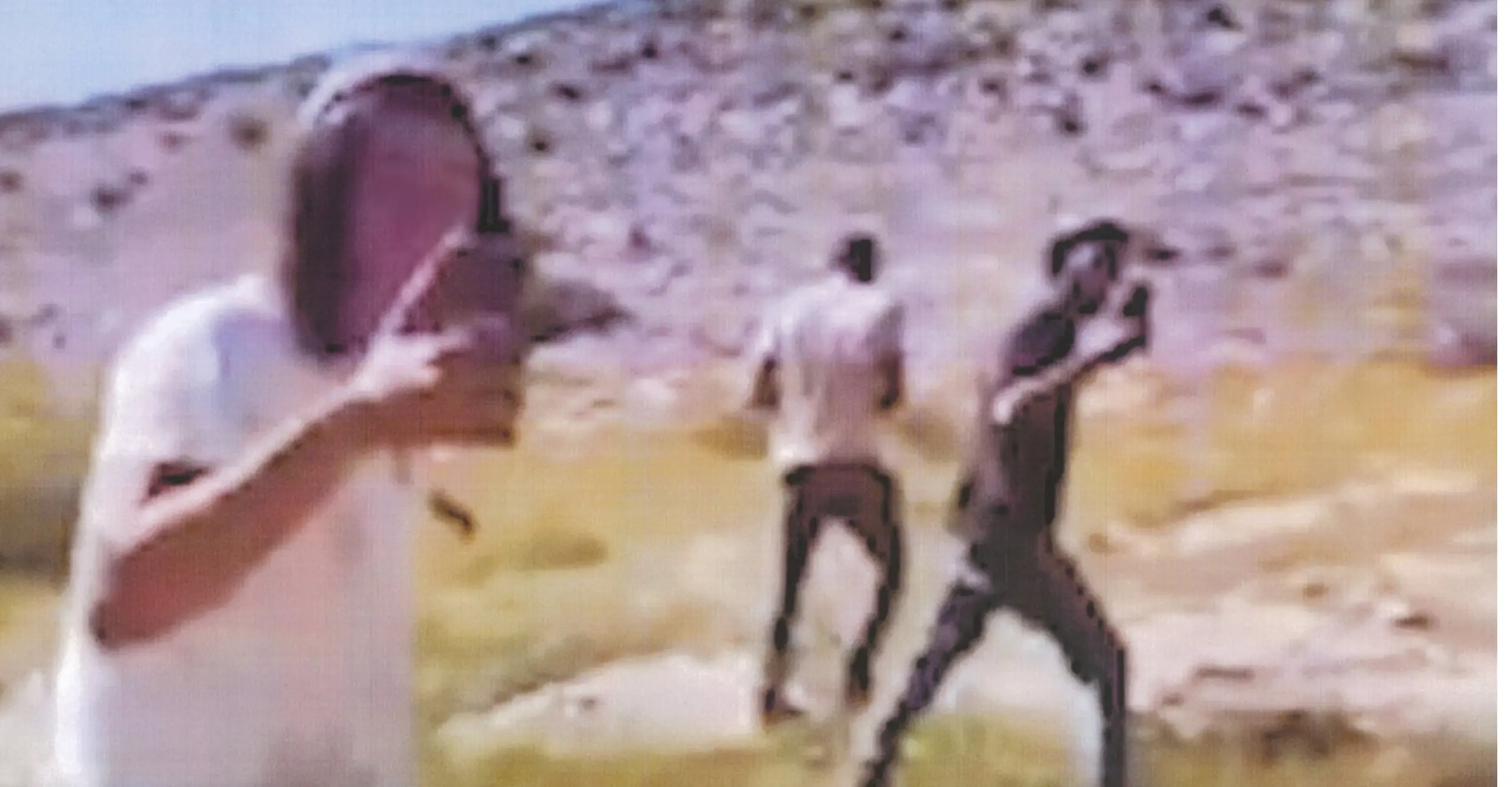 blurry image of 3 men on a mountain side