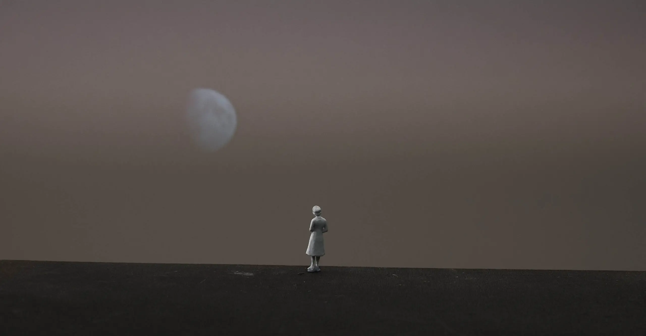 A photograph on a person looking at the moon.