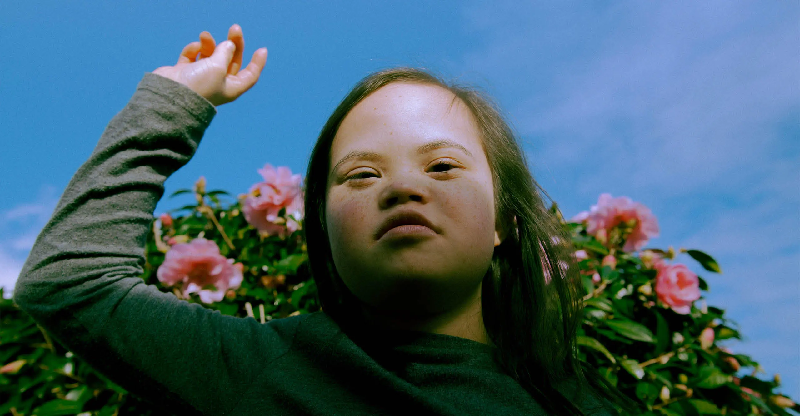 image of a girl standing in front of a rose bush by Anna Neubauer as part of The Photographers’ Gallery's temporary exhibition taking place in Kings Cross 