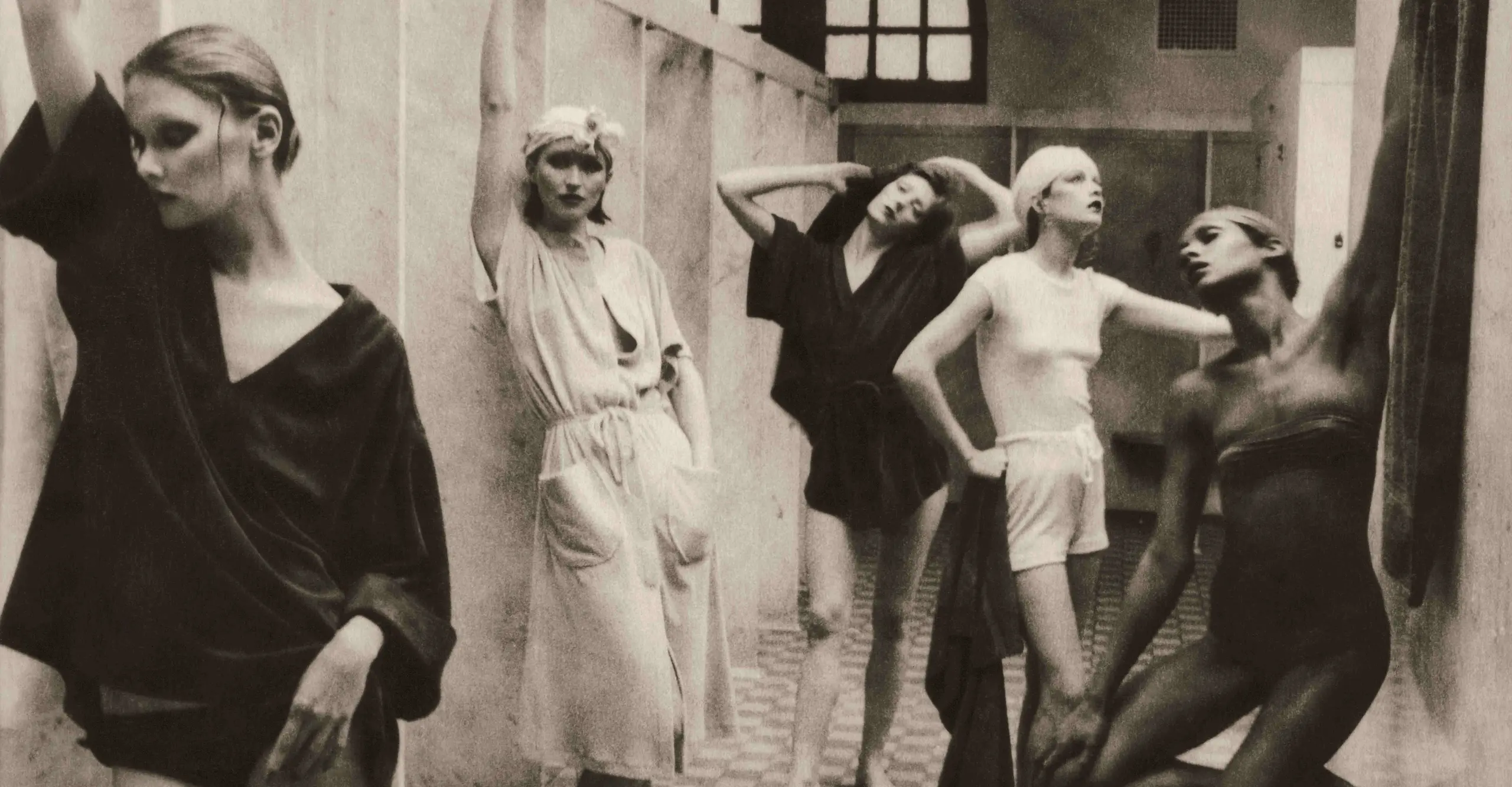 Photograph of five women standing and posing in a bathhouse.