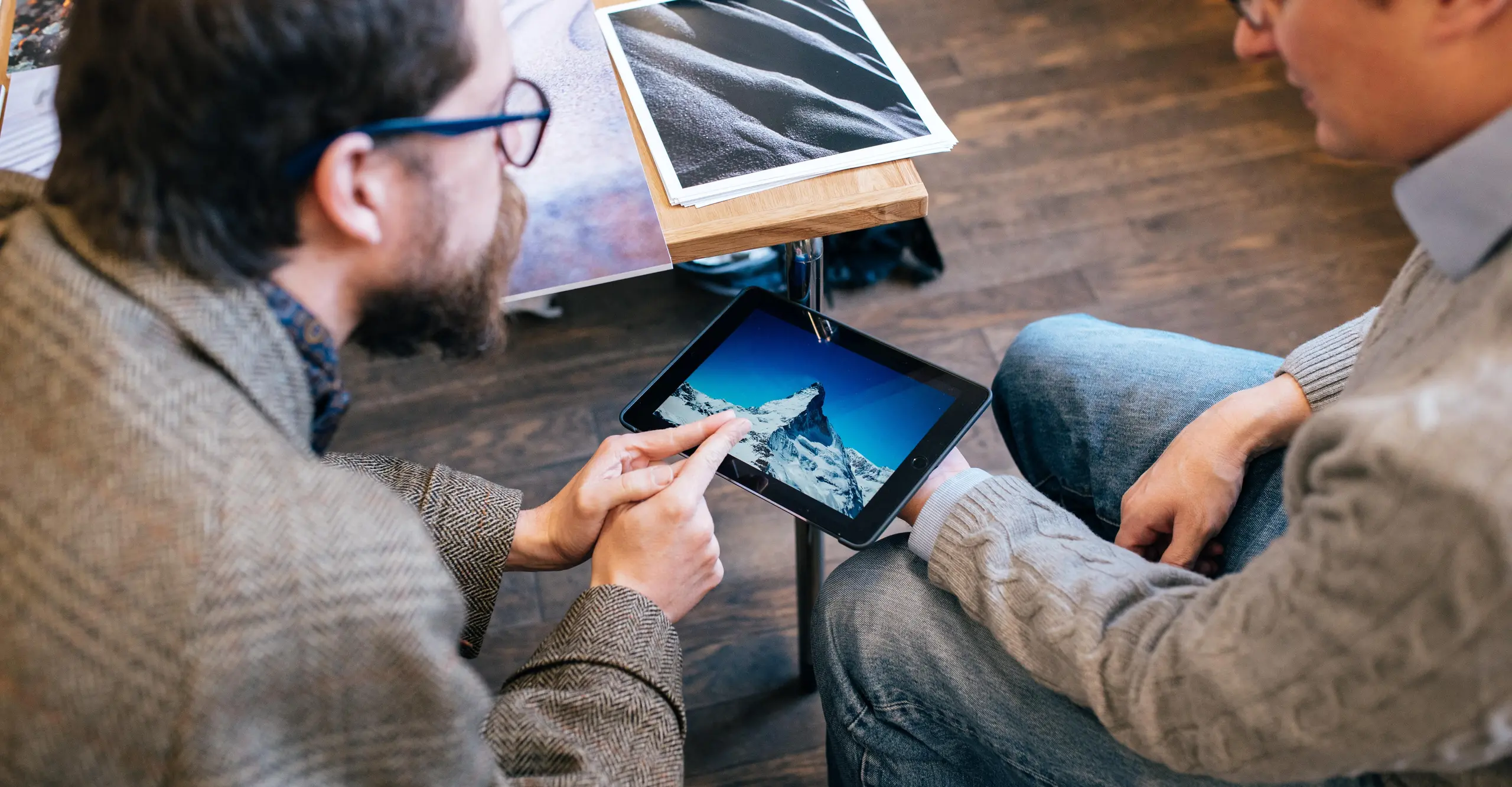 Two people sit together discussing photographs