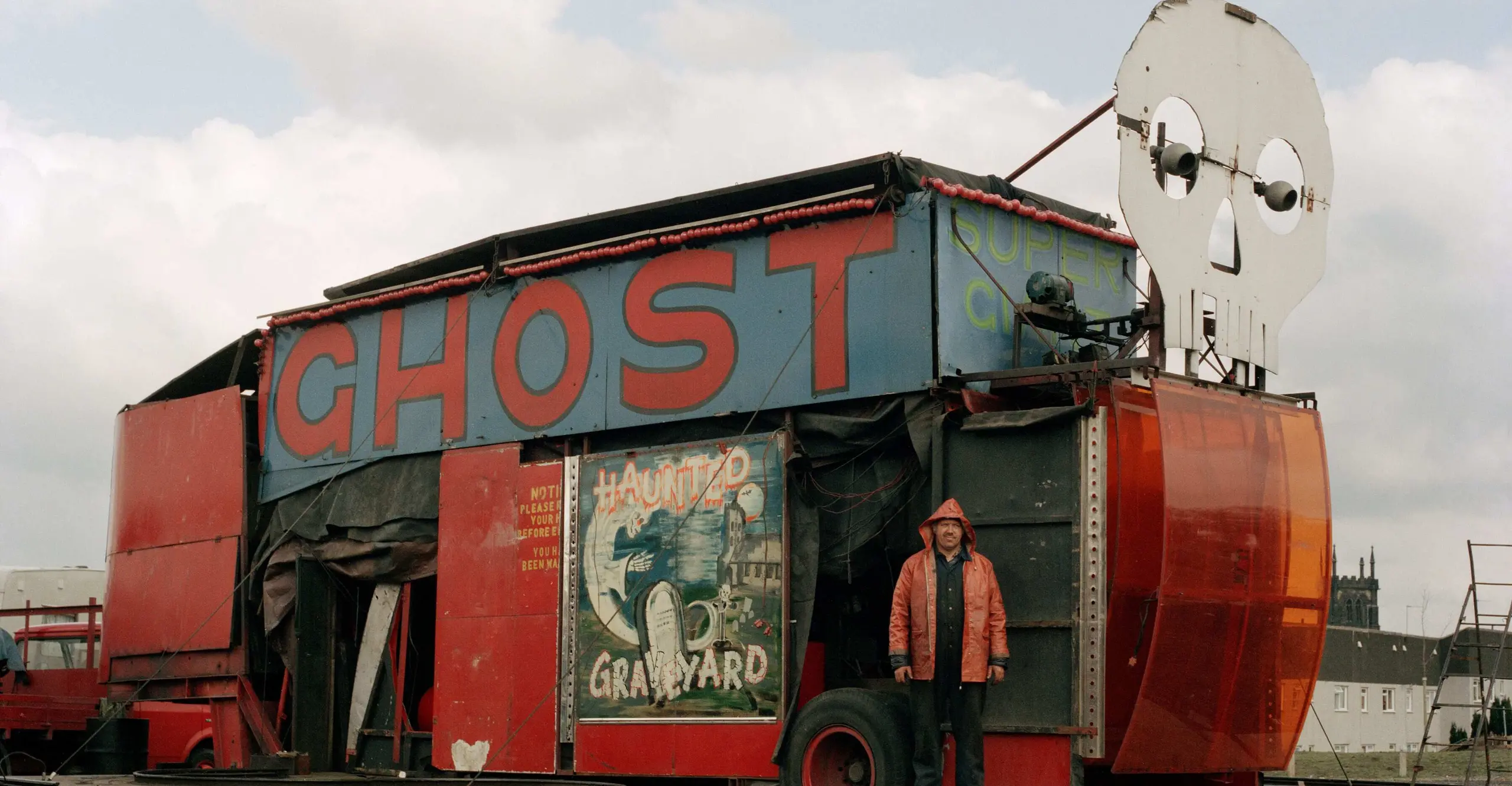 A colour image of a fairground ghost train amusement ride that looks run down.