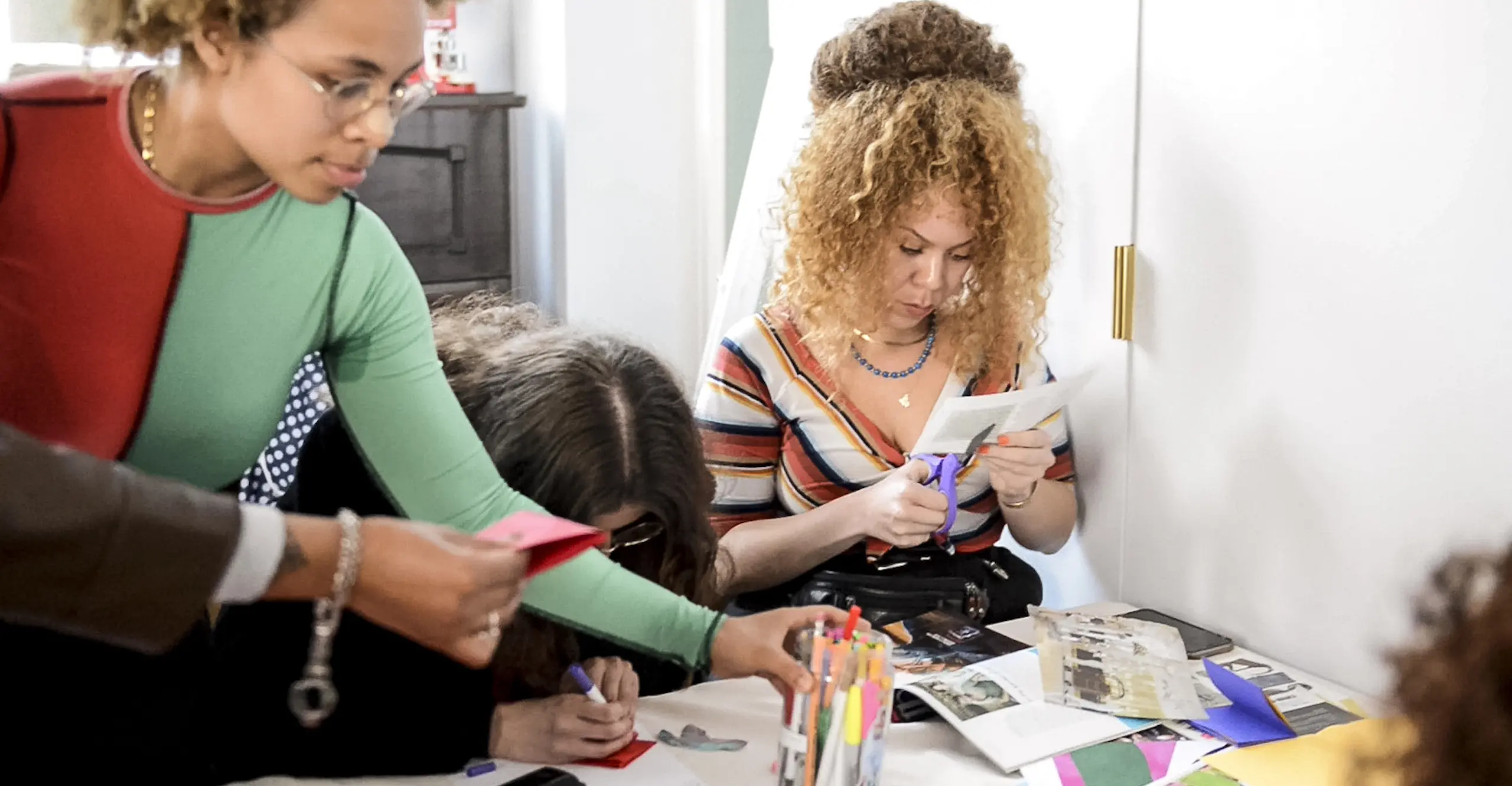 Photo of a group of people taking part in a zine making workshop.