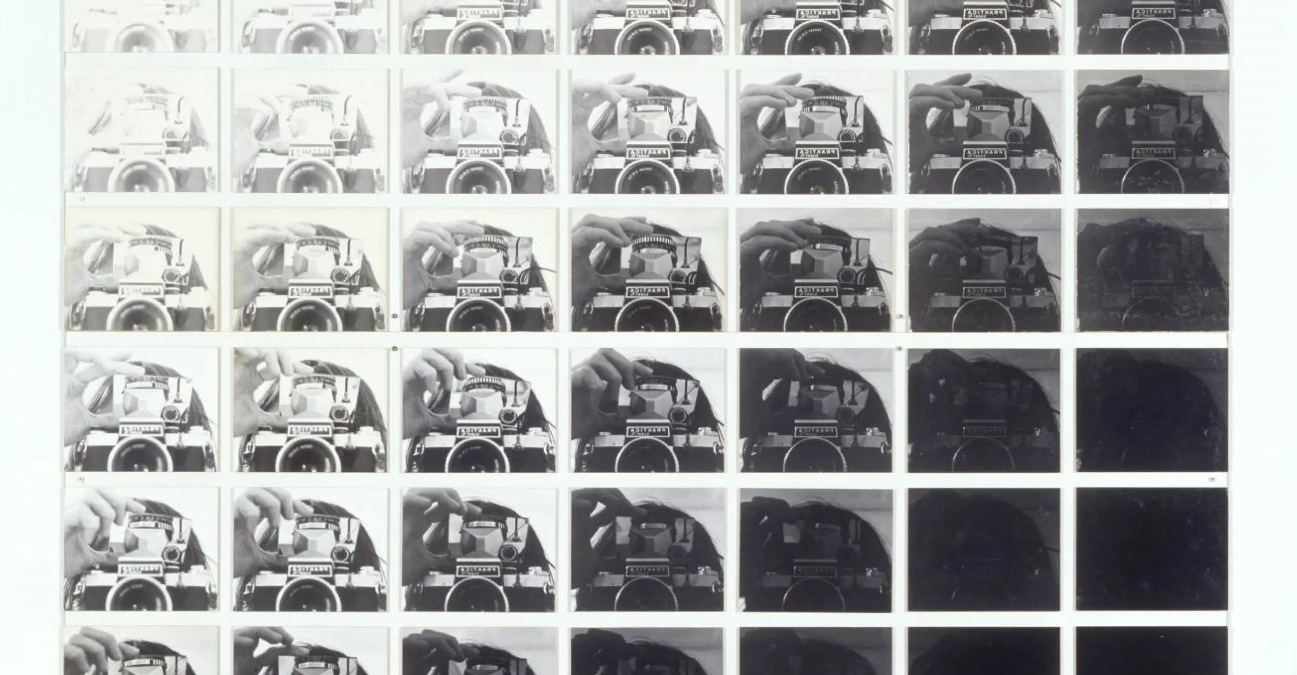 Grid of replicated black and white images of a camera, going from white to black