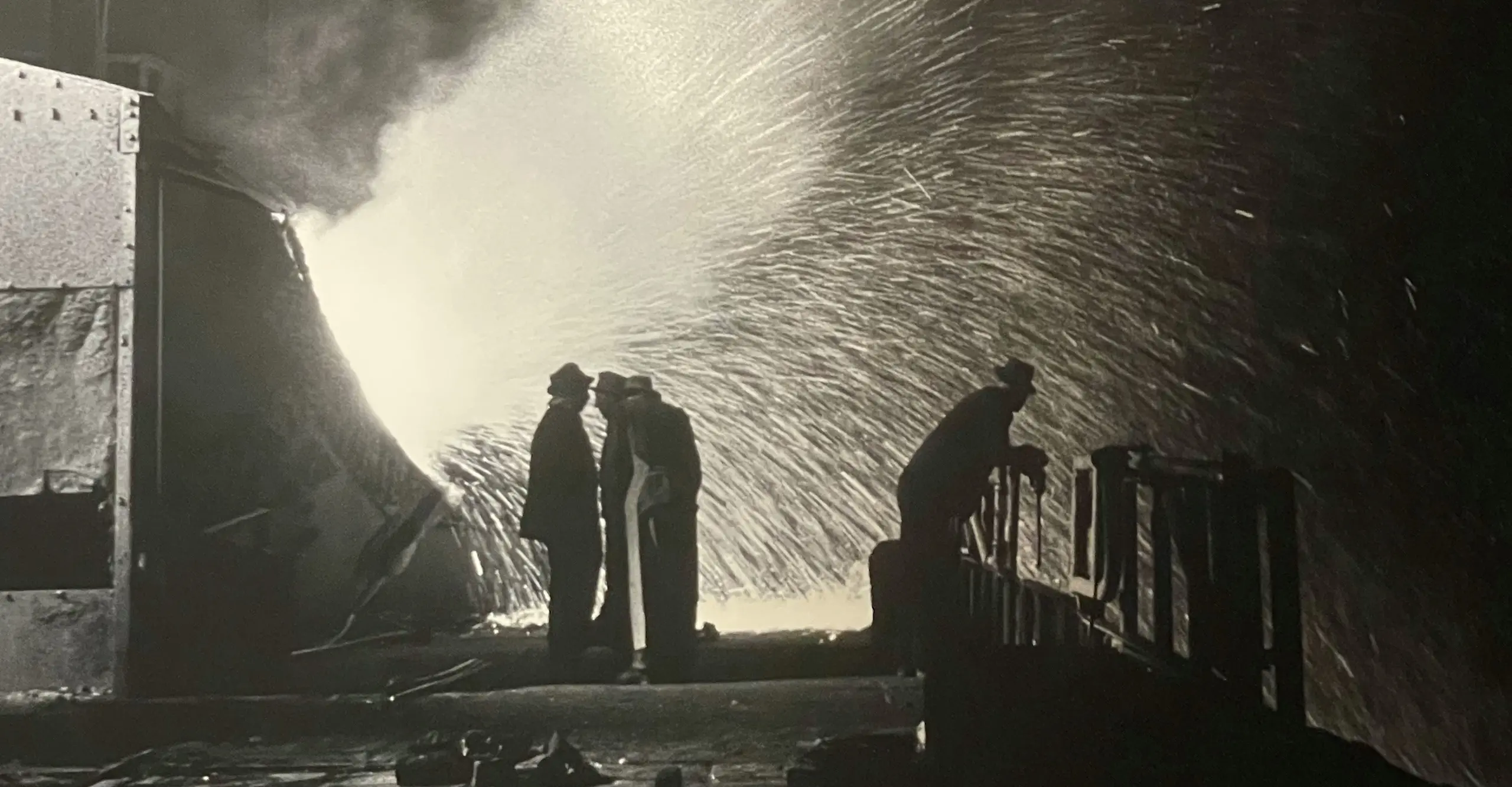 Black and white image of people in industrial space.