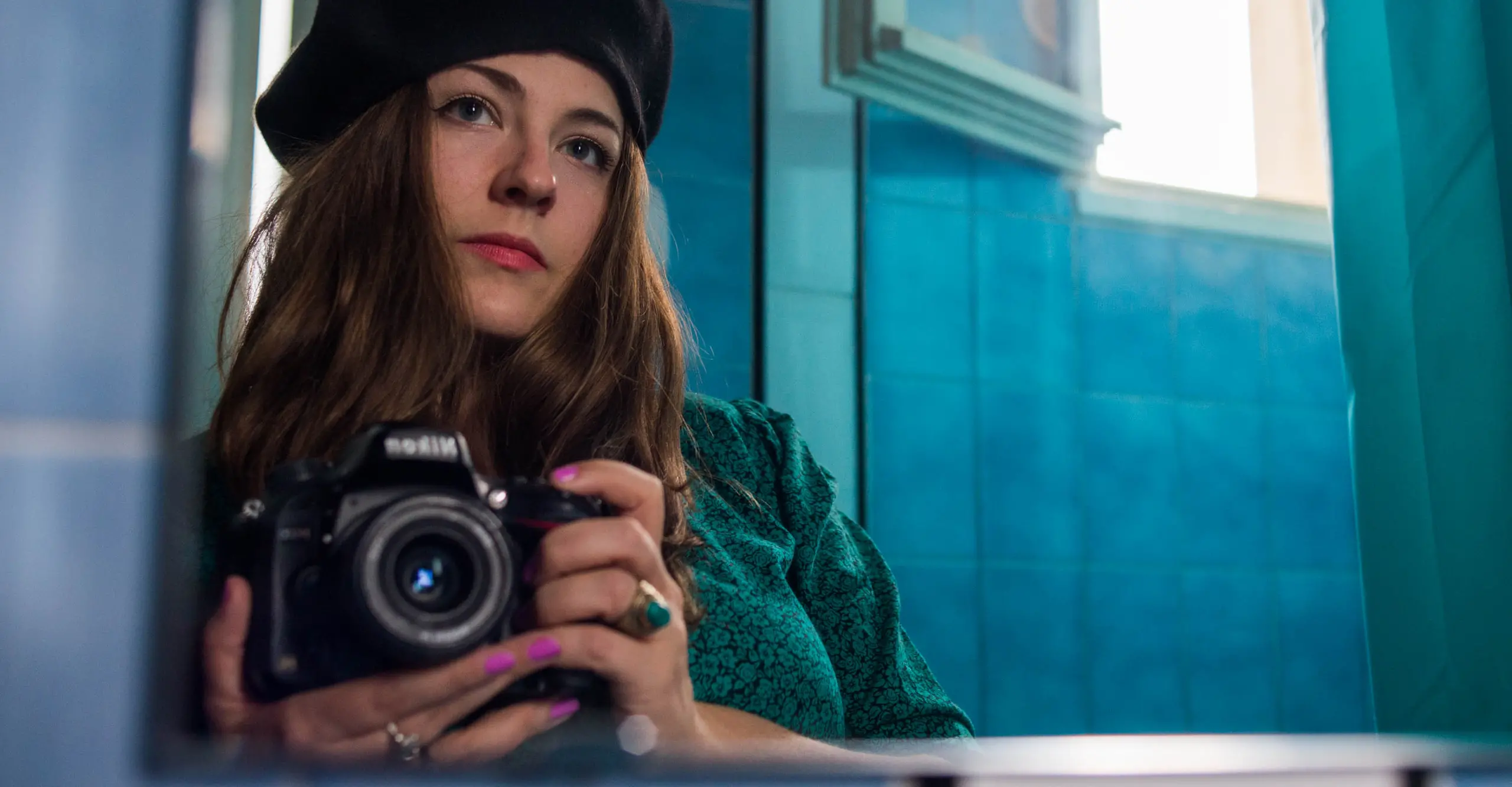 A photograph of  a person taking a photograph in a mirror.