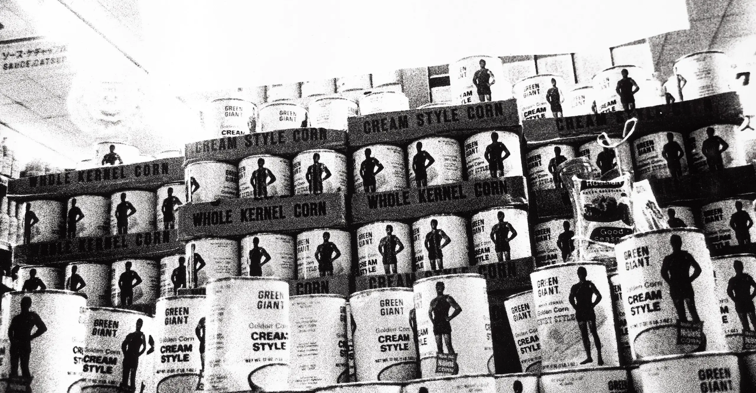 Grainy black and white photograph of a display of tinned food