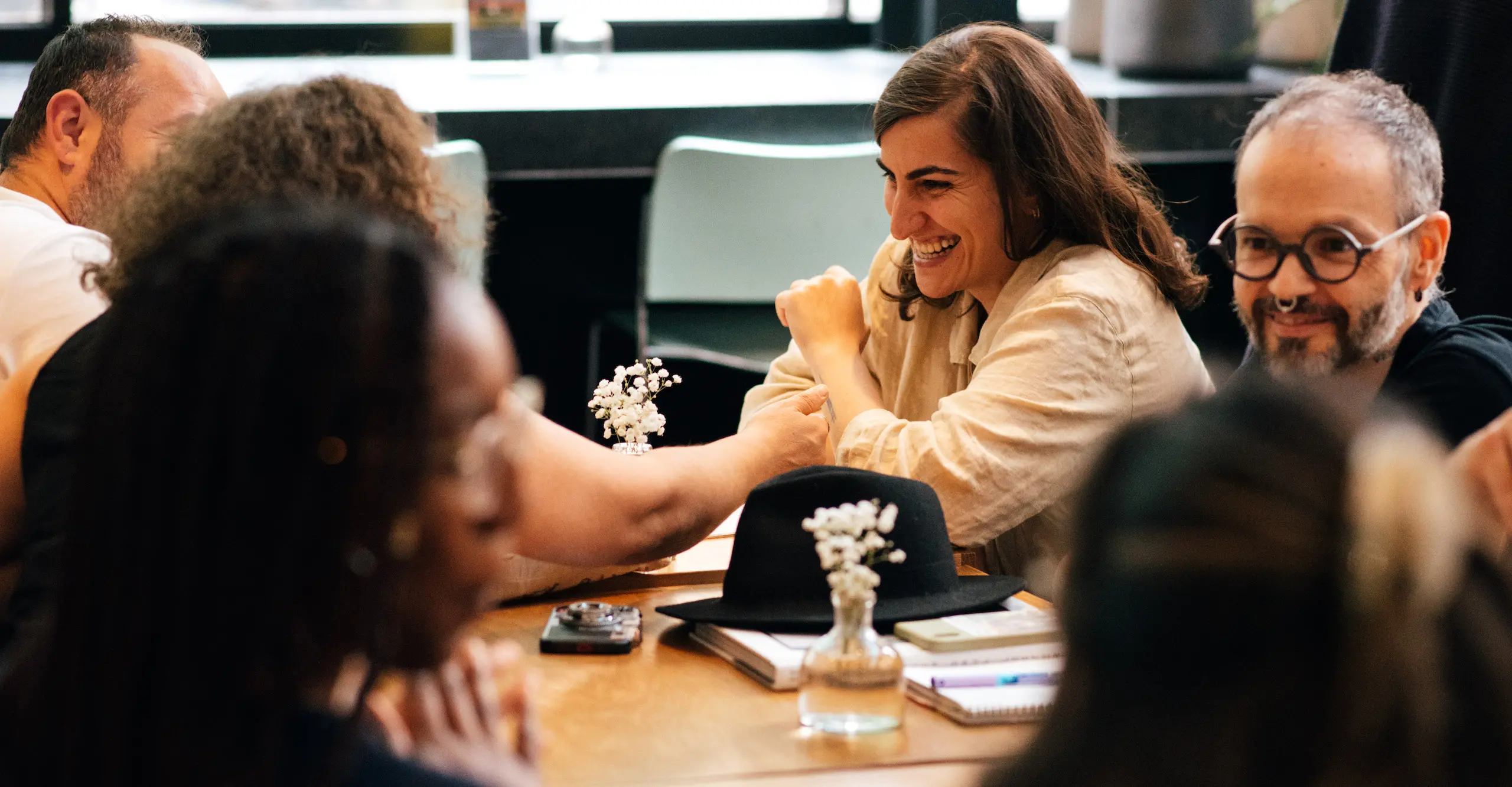 Colour photograph of people sitting at tables socialising