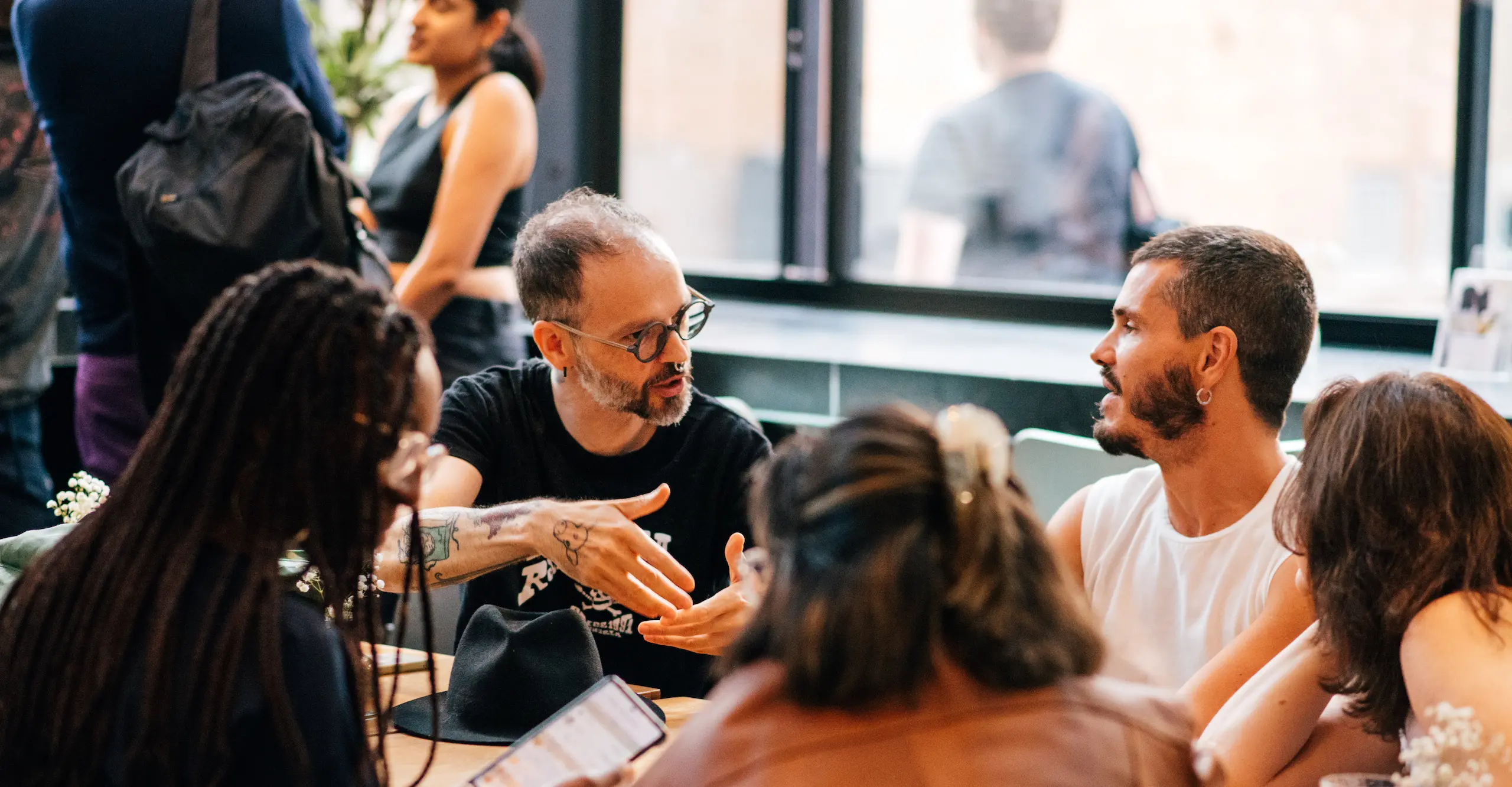 Colour photograph of people sitting at tables socialising