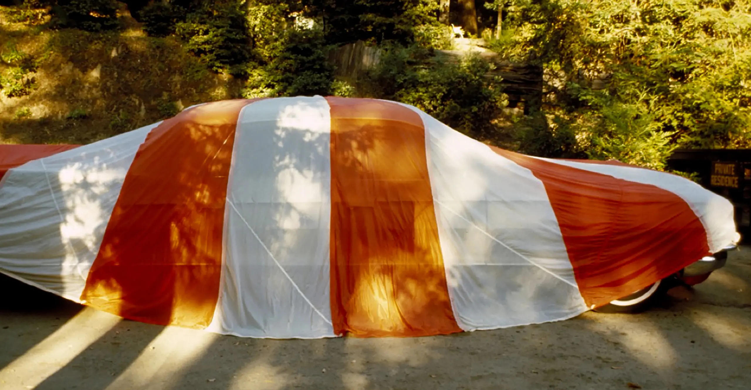 colour photograph of car covered in a tarpaulin