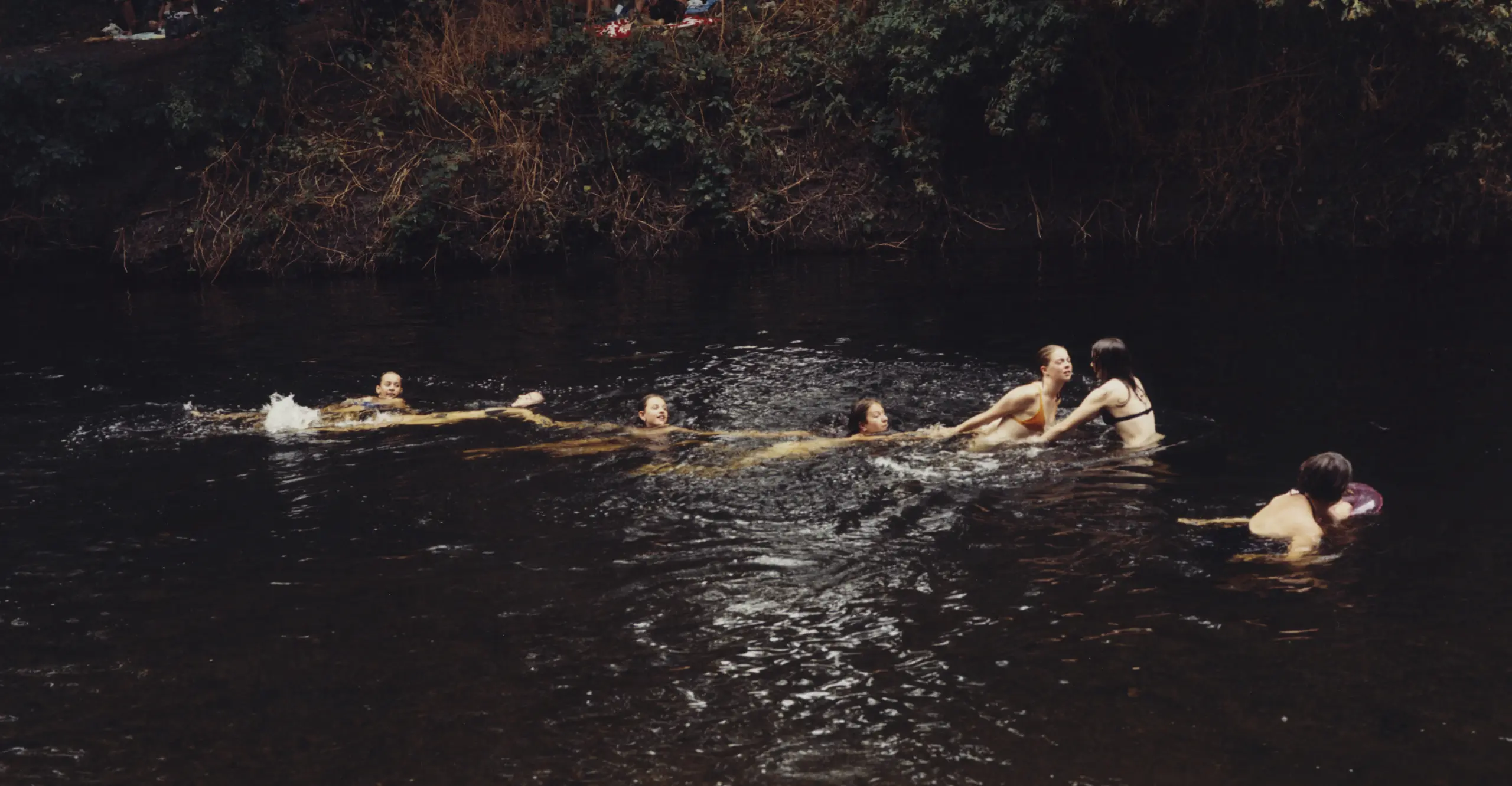 young people frolicking in the murky waters of Hackney