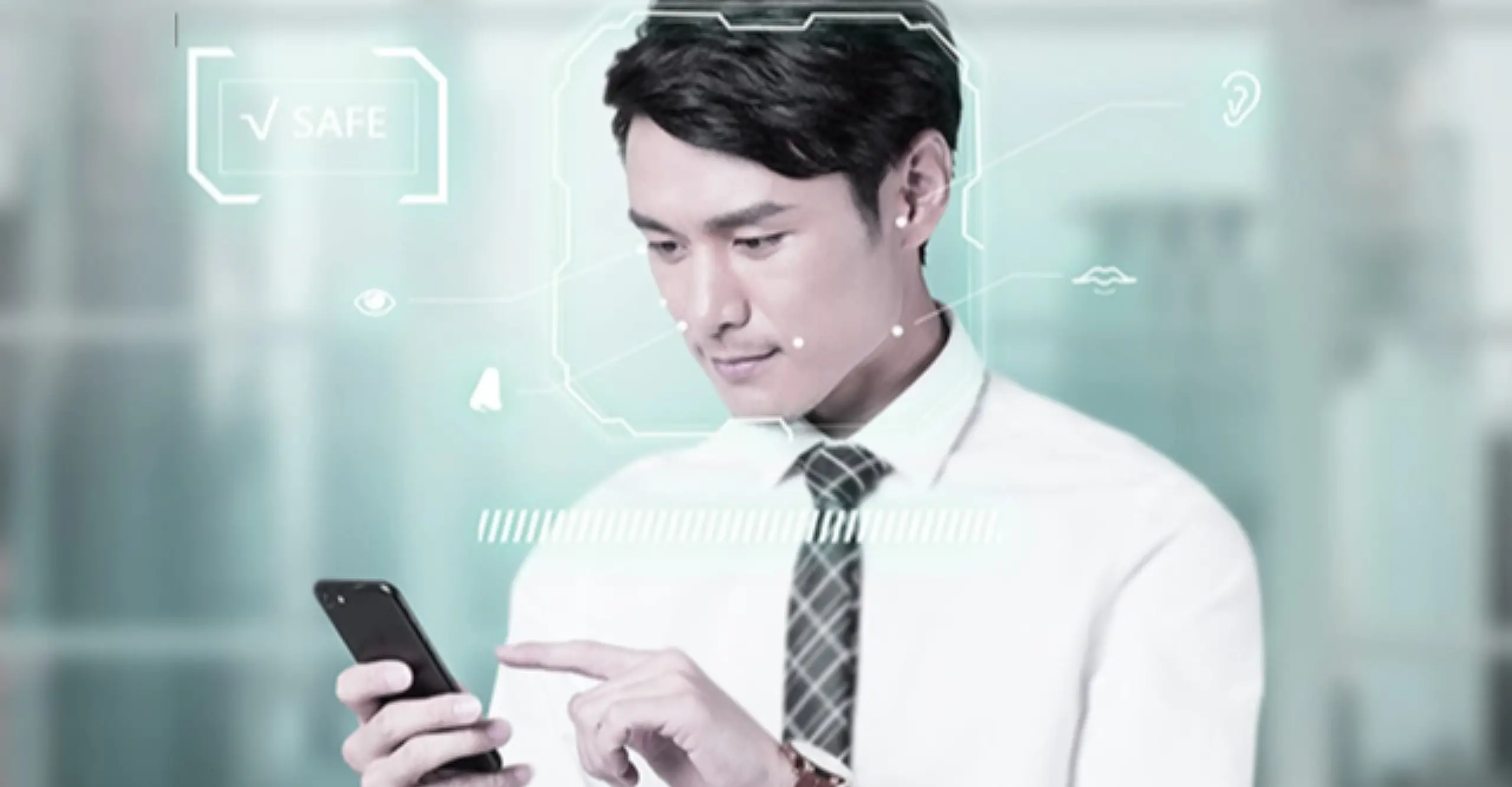 A man wearing a white shirt and a tie holding a phone in an office