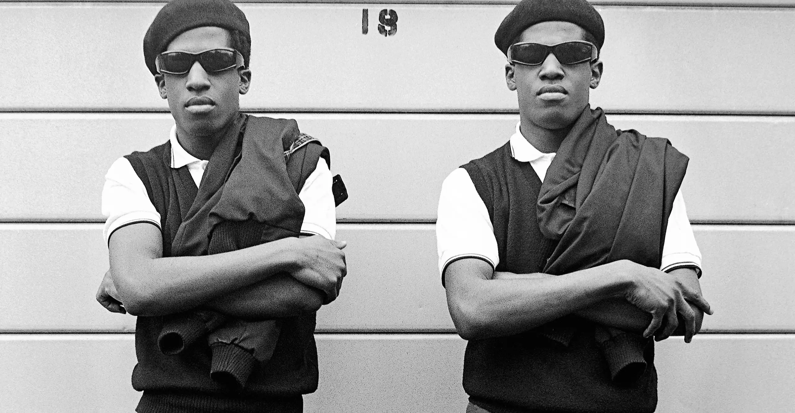 black and white photograph of two black men wearing identical clothing by janette beckman