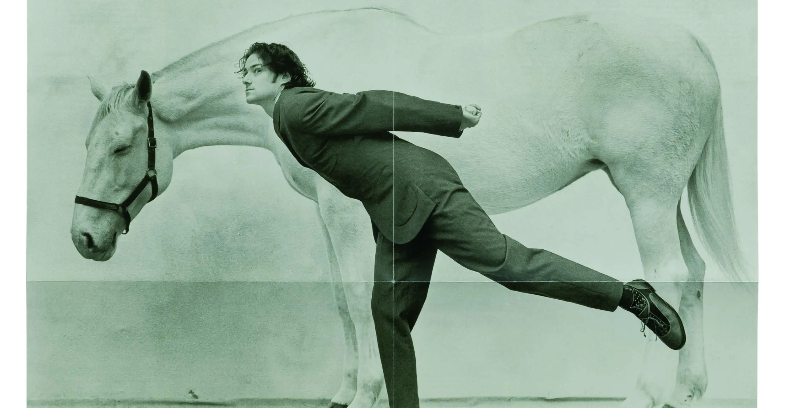 Black and white image of a man leaning over a horse